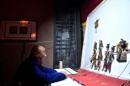 (miniature) L'artiste folklorique Yao Yasheng exécute un spectacle d'ombres chinoises dans l'arrondissement de Ping'an à Haidong