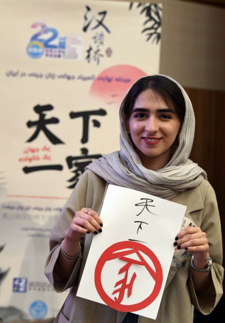 (miniature) Une participante montre son oeuvre lors de la 22e édition du concours de maîtrise du mandarin Pont vers le chinois pour les étudiants iraniens à Téhéran