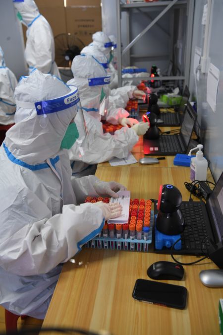 (miniature) Des professionnels de santé scannent les codes des échantillons d'acide nucléique dans un laboratoire de dépistage à Sanya
