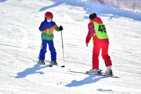 (miniature) Une monitrice apprend à un enfant à faire du ski dans une station de sports d'hiver à Shijiazhuang