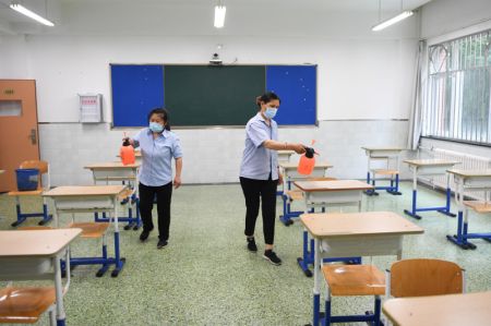 (miniature) Des employées désinfectent une salle de classe à l'école secondaire No