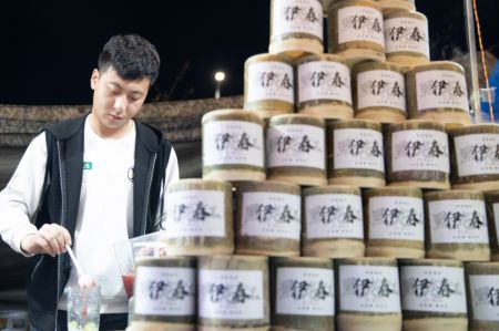 (miniature) Un vendeur prépare des boissons dans un marché de nuit à Yichun