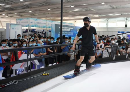 (miniature) Un homme fait la démonstration d'un appareil de simulation de ski lors du Salon international du commerce des services de Chine 2020