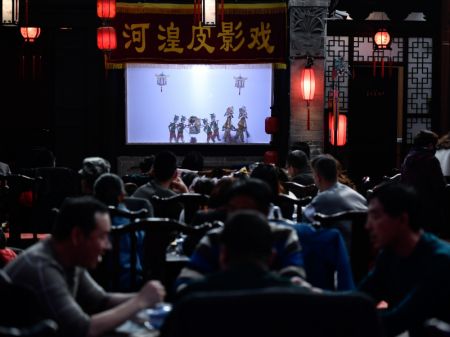(miniature) Des visiteurs regardent un spectacle d'ombres chinoises dans l'arrondissement de Ping'an à Haidong