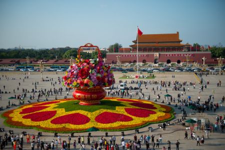 (miniature) Des touristes se promènent autour d'un panier de fleurs sur la place Tian'anmen à Beijing