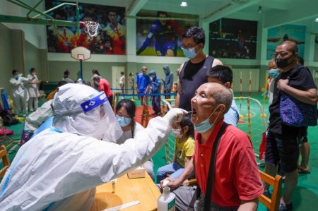 (miniature) Un membre du personnel médical prélève un échantillon de gorge sur une personne âgée pour des tests d'acide nucléique