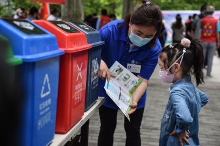 (miniature) Une jeune fille apprend les règles de tri des déchets lors d'une campagne de sensibilisation à la gestion des déchets dans une communauté résidentielle de l'arrondissement de Dongcheng à Beijing