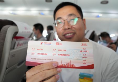 (miniature) Un passager présente sa carte d'embarquement d'un vol entre Shanghai et Beijing à bord d'un C919