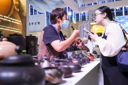 (miniature) Un exposant (à gauche) présente des produits en céramique à une visiteuse lors de la 7e Exposition Chine-Asie du Sud à Kunming