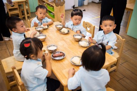 (miniature) Des enfants prennent le petit-déjeuner dans une école maternelle à Changsha