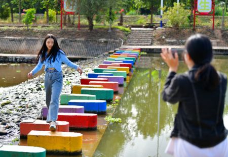 (miniature) Une touriste pose pour des photos sur une digue récemment aménagée dans le village de Zhikeng