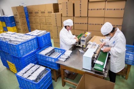 (miniature) Des membres du personnel emballent des médicaments dans une entreprise pharmaceutique de la province chinoise du Hunan (centre)