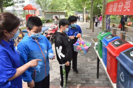 (miniature) Deux enfants jouent à un jeu éducatif sur le tri des déchets lors d'une campagne de sensibilisation à la gestion des déchets dans une communauté résidentielle de l'arrondissement de Dongcheng à Beijing