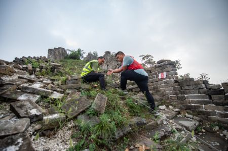 (miniature) Le technicien Yang Zhanjie (à droite) et son collègue ont établi une ligne de démarcation autour de la zone de fouilles archéologiques de la partie de la restauration basée sur la recherche de la section Jiankou de la Grande Muraille