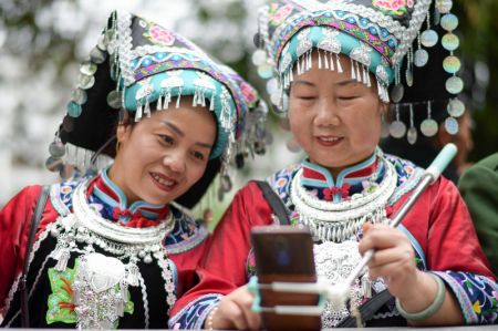 (miniature) Deux femmes se prennent en selfie lors d'une parade pour célébrer la Fête des soeurs Miao dans le district de Taijiang