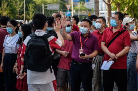 (miniature) Un enseignant encourage un candidat à l'extérieur d'un site d'examen à Beijing