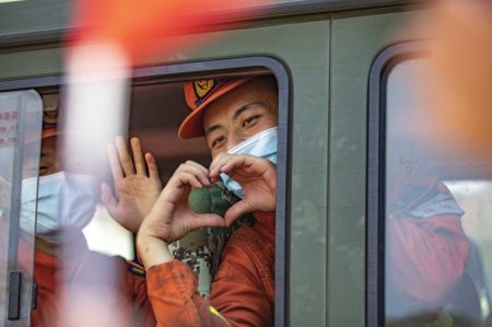 (miniature) Un pompier de la province du Yunnan fait un coeur avec les mains en signe d'au revoir aux habitants de l'arrondissement de Beibei