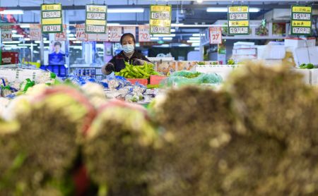 (miniature) Une employée arrange des légumes dans un supermarché de l'arrondissement de Dongchang de Tonghua