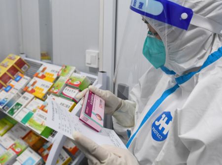 (miniature) Une professionnelle de santé vérifie une prescription dans une clinique de traitement de la fièvre de l'arrondissement de Weiyang