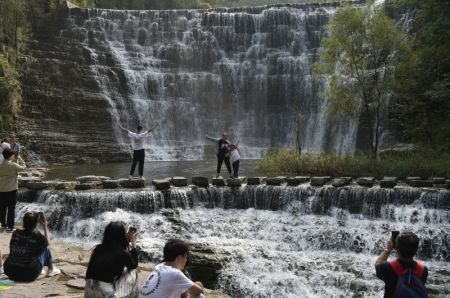 (miniature) Des touristes prennent des photos devant une chute d'eau dans le Grand canyon de Taihang à Linzhou