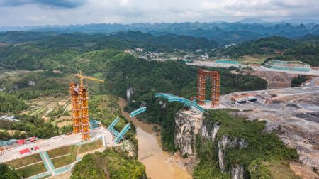 (miniature) Photo aérienne prise par un drone le 18 avril 2024 montrant le pont de la rivière Lami sur le tracé de l'autoroute Guiyang-Pingtang en construction dans la province chinoise du Guizhou (sud-ouest)