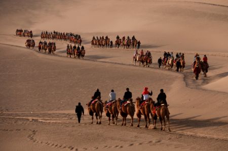 (miniature) Des touristes montent à dos de chameaux dans la zone touristique de la montagne Mingsha et du lac Crescent pendant les congés de la fête nationale à Dunhuang