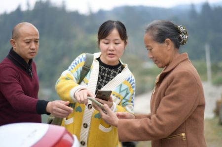 (miniature) Une employée (au centre) montre à une villageoise comment payer sa facture de téléphone portable dans le village de Balu