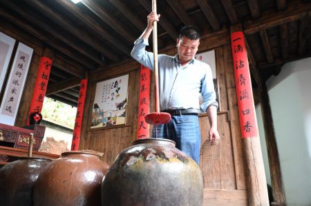 (miniature) Le villageois Wu Shandi présente le processus de brassage dans une salle de démonstration consacrée au vin jaune dans le village de Beiqian du bourg de Daixi