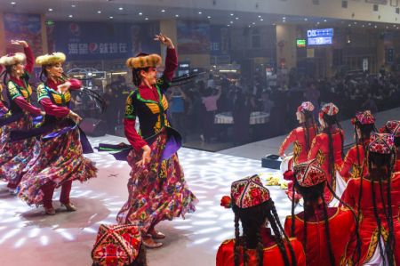 (miniature) Des danseuses se produisent sur scène dans un marché de nuit à Hotan
