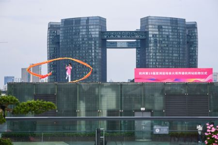 (miniature) Un artiste présente un numéro lors du relais de la flamme des Jeux asiatiques de Hangzhou