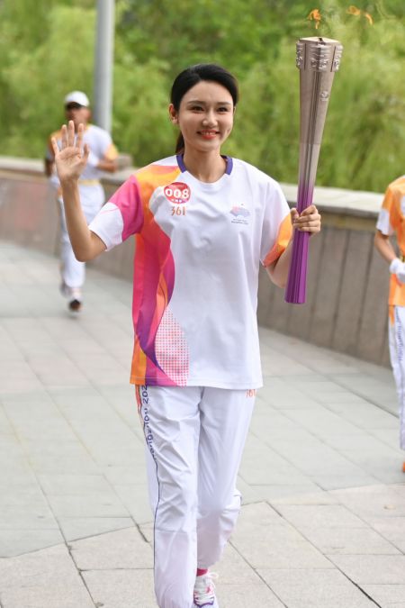 (miniature) La porteuse de la torche Long Yang court lors du relais de la flamme des Jeux asiatiques de Hangzhou