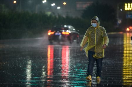 (miniature) Un homme marche sous la pluie
