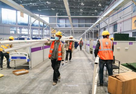 (miniature) Des ouvriers travaillent sur le chantier d'un hôpital temporaire au Centre national des expositions et des congrès (Shanghai)