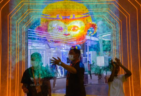 (miniature) Des visiteurs font l'expérience de la projection holographique dans la zone d'exposition des services de télécommunications