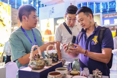 (miniature) Un exposant (à gauche) présente des produits en céramique lors de la 7e Exposition Chine-Asie du Sud à Kunming