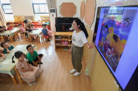 (miniature) Une enseignante raconte des histoires sur les aliments dans un jardin d'enfants à Changsha