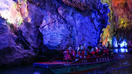 (miniature) Des visiteurs prennent des bateaux pour visiter une grotte karstique dans le site pittoresque du palais Loong
