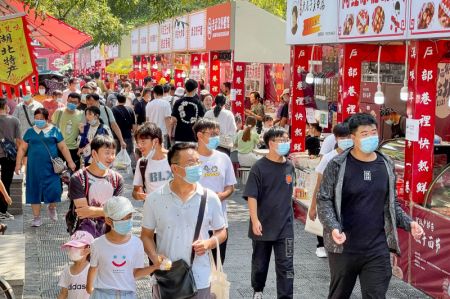 (miniature) Des gens visitent une rue avec des stands gastronomiques durant les congés d'une semaine de la fête nationale
