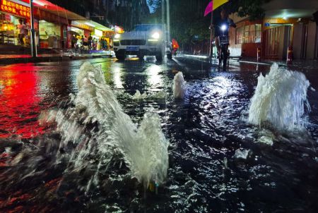 (miniature) L'eau jaillit des bouches d'égout dans une rue à Guangzhou