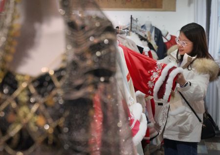 (miniature) Une touriste choisit des habits traditionnels dans un magasin de l'ancienne ville de Luoyi